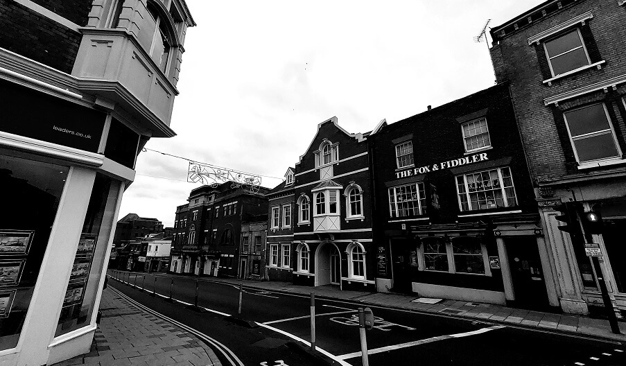a black and white image of the fox and fiddler pub and other buildings on st johns street